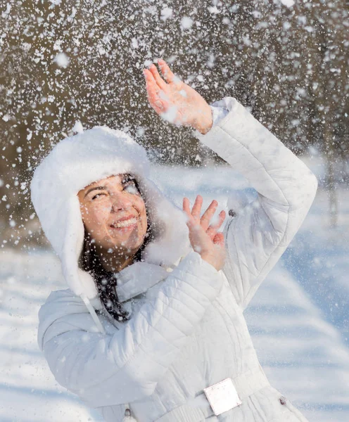 Счастливая девушка играет со снегом — стоковое фото