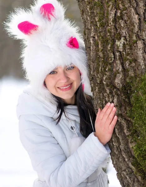 Woman hiding behind tree in winter season — Stock Photo, Image