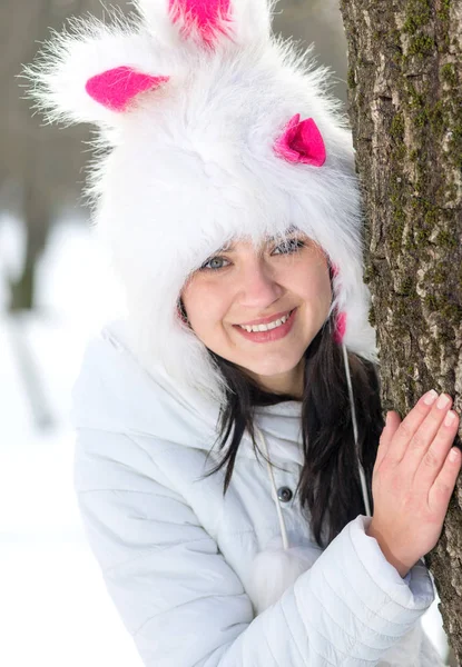 Kvinna som gömmer sig bakom träd i vintersäsongen — Stockfoto