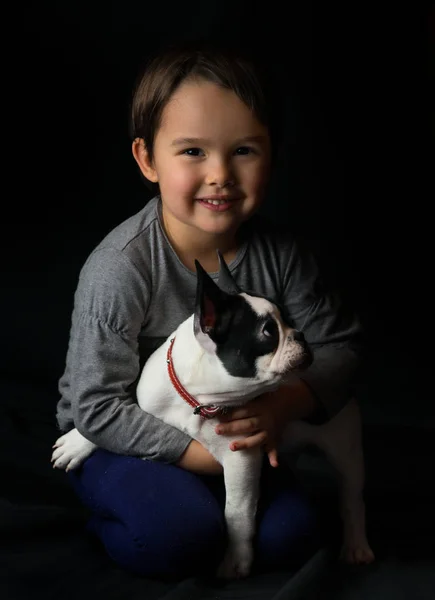 French bulldog and little girl playing isolated on black background — Stock Photo, Image