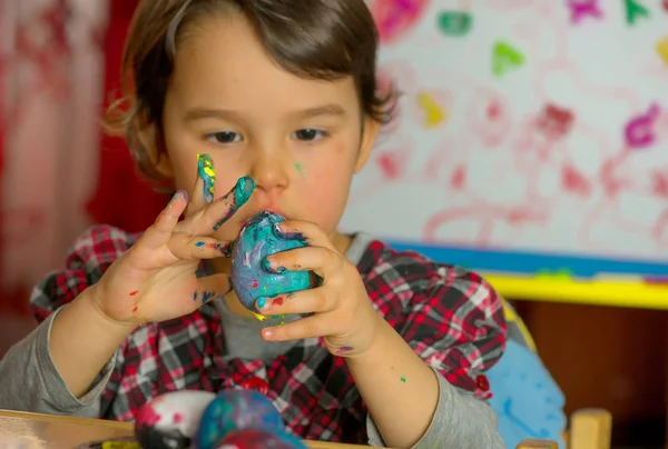 Bambina disegna intensamente le immagini sulle uova con acquerelli — Foto Stock