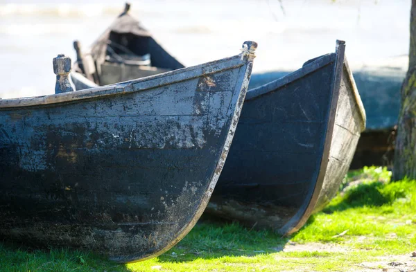 Velhos barcos atracados perto de uma ponte de madeira podre no lago — Fotografia de Stock