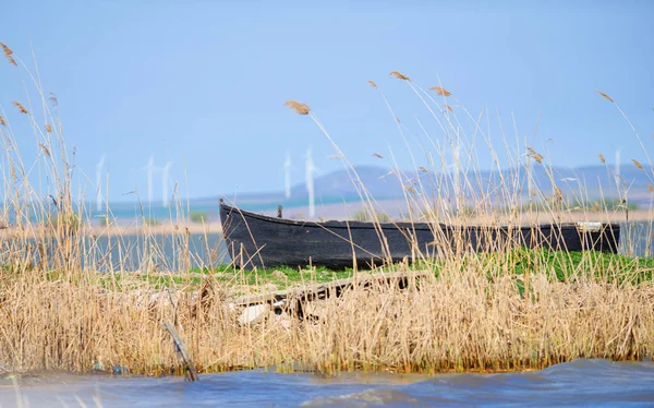 Stará loď kotvící poblíž shnilé dřevěný most na jezeře — Stock fotografie