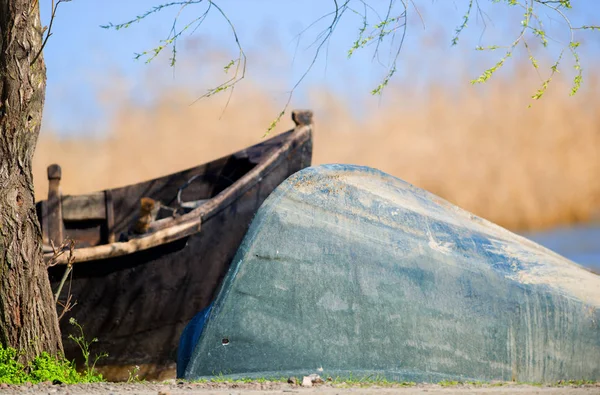 Um velho barco de madeira virou de cabeça para baixo na grama verde — Fotografia de Stock