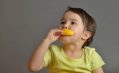 küçük kız bir limon yemek