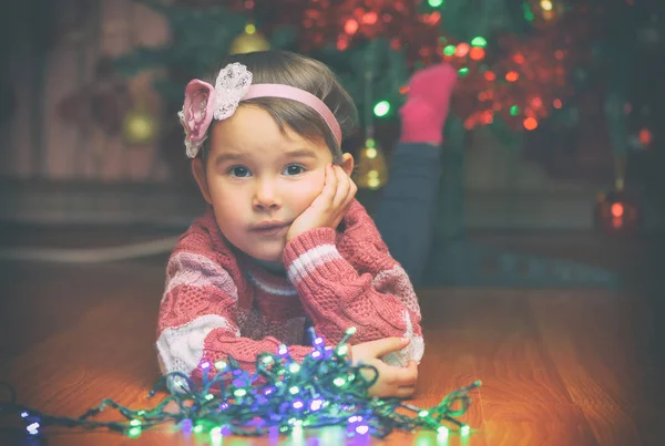Portrait of cute little girl with Christmas tree on background — Stock Photo, Image