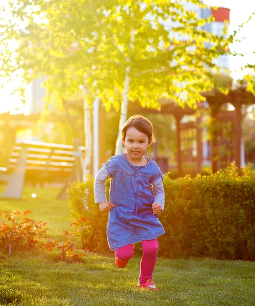 Bambino che corre attraverso l'erba nel parco — Foto Stock