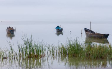 Gün batımında göl kenarında eski kürekli
