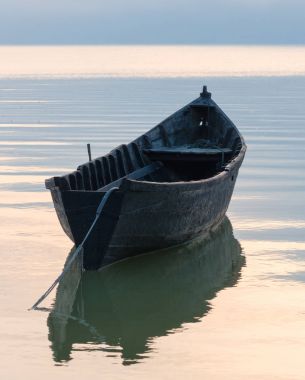 Gün batımında göl kenarında eski kayık