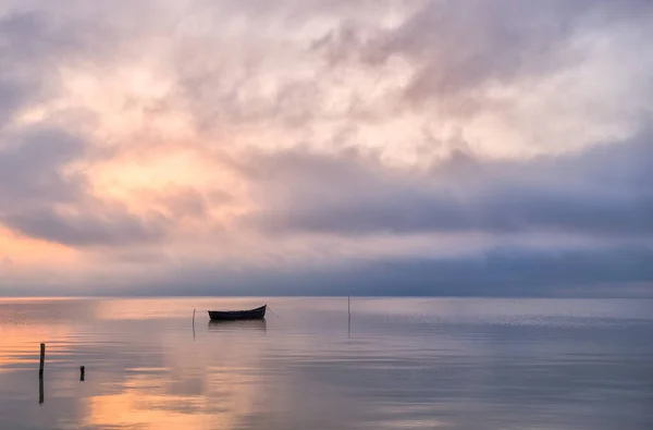 Old rowboat on the lake at sunset — Stock Photo, Image