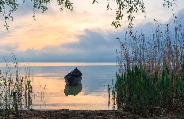 Oude roeiboot op het meer bij zonsondergang — Stockfoto