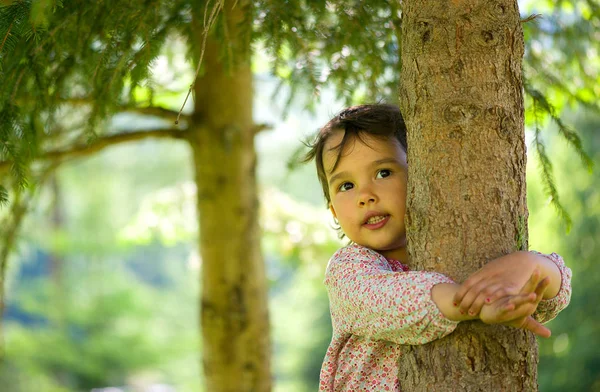 Ağacın yanında oynayan küçük kız — Stok fotoğraf