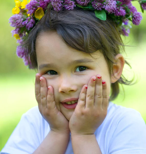 Retrato de una chica alegre con una corona de flores en la cabeza —  Fotos de Stock