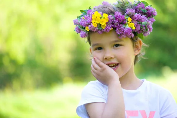 Portrét veselá dívka s věncem květů na hlavu — Stock fotografie