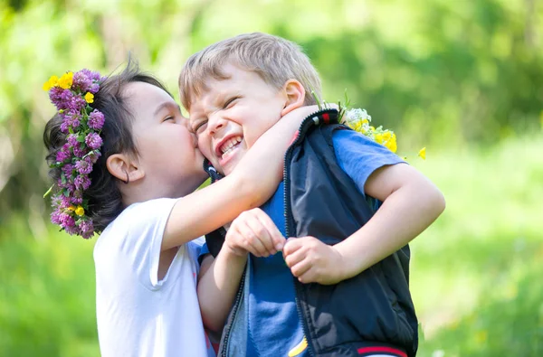 Lilla flickan kysser en liten pojke — Stockfoto