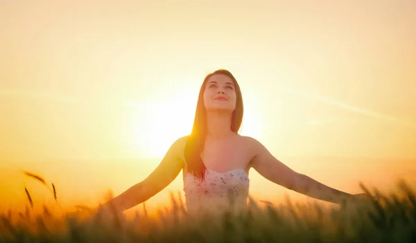 Piękna kobieta z kapelusz lato w polu pszenicy o zachodzie słońca — Zdjęcie stockowe