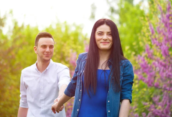 Junge Frau hält Mann die Hand und führt ihn in die Natur — Stockfoto