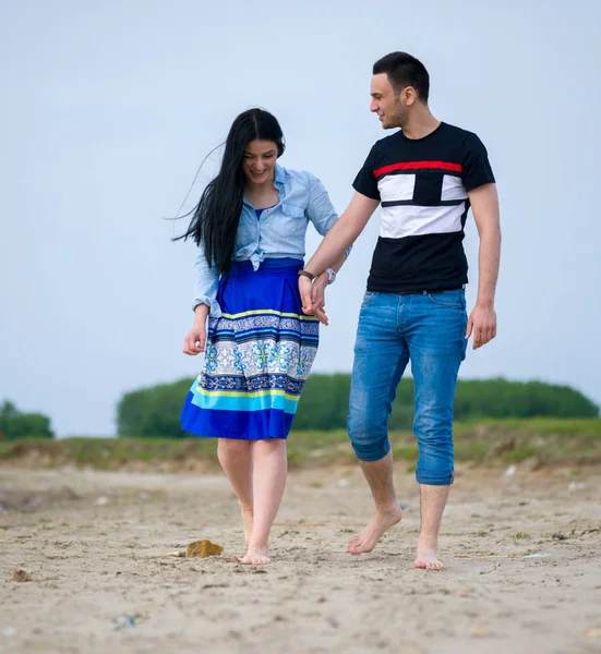 Dos amantes tomados de la mano y caminando por la playa —  Fotos de Stock