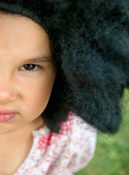 Espacio de copia y media cara de niña pequeña con una gran peluca negra —  Fotos de Stock
