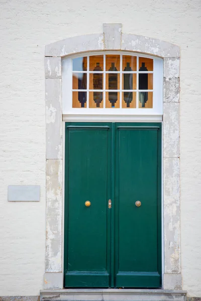 Зеленая дверь в старом каменном доме — стоковое фото