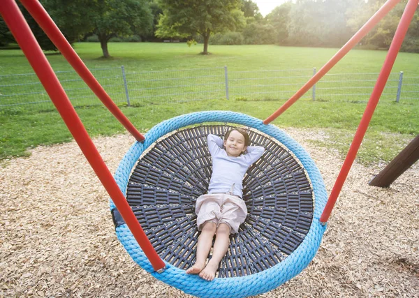 Bambina divertendosi in uno swing arrotondato — Foto Stock
