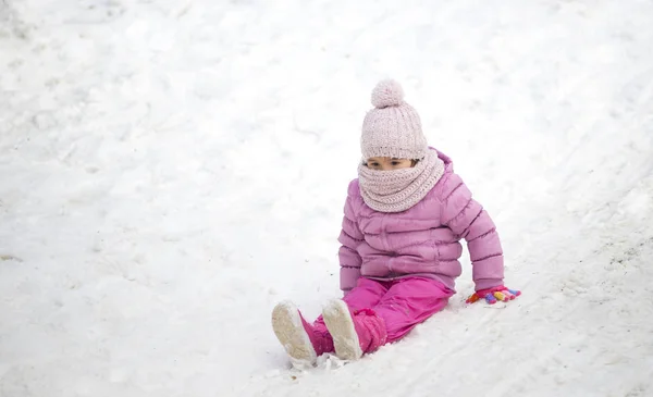 young child playing in the snow