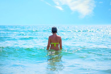 Denizin üzerinde oldukça genç bir kadın arkadan görünüm