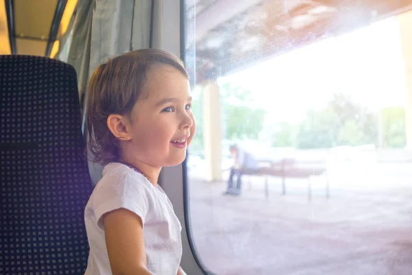 Happy little girl traveling by train