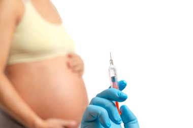 Doktor el, beyaz arka planda izole edilmiş hamile kadının karnına pıhtılaşma önleyici enjekte etmeye hazırlanıyor.