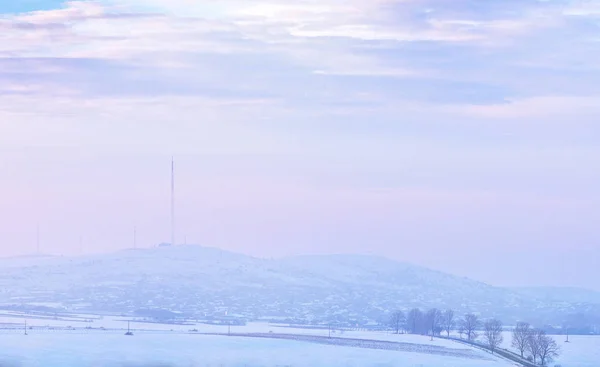 雪で覆われた丘に沈む夕日 — ストック写真