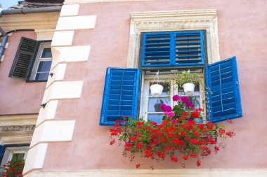 Tuğla evde gün ışığında mavi pencereler