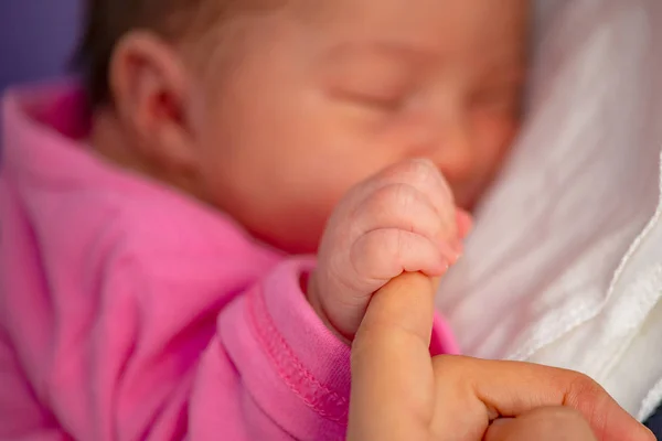 新生児は母親の指をベッドの上に置くと — ストック写真