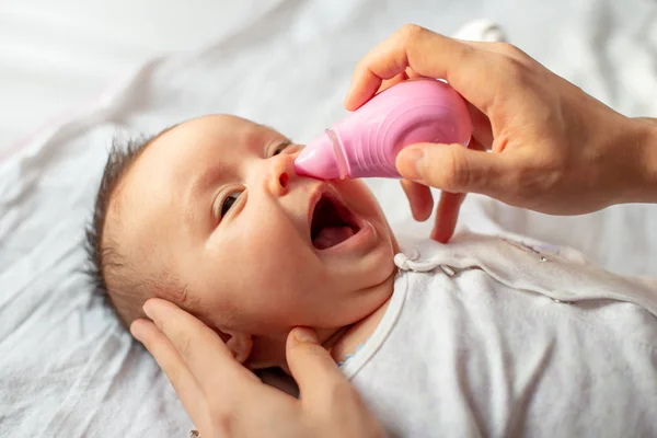 赤ちゃんの鼻吸引器を使った母親の鼻吸引 — ストック写真