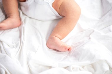 Bebek bacakları ve beyaz yatak arka plan, üstten görünüm, bez alt uzay kopyalayın