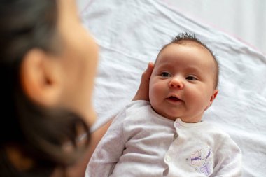 Annesinin kollarında yeni doğmuş bir bebeğin en iyi görüntüsü