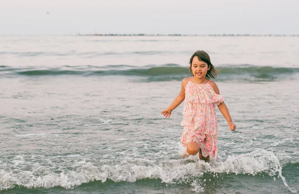 Pembe Elbiseli Küçük Kız Deniz Suyunda Eğleniyor — Stok fotoğraf