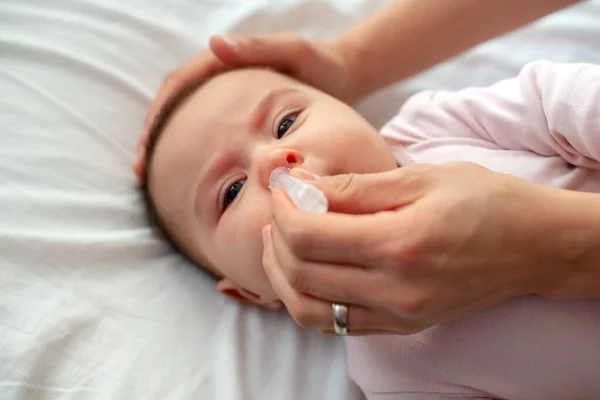 Zbliżenie Opiekuńczej Matki Pompą Nosa Czyszczenia Nosa Dziecka Dziecko Leżące — Zdjęcie stockowe