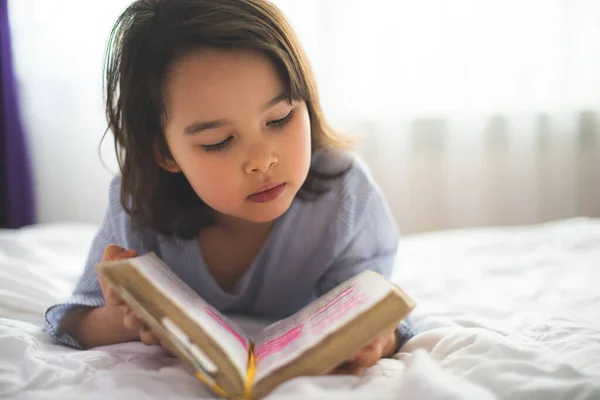 Маленькая Девочка Читает Библии Пока Постели Утром — стоковое фото