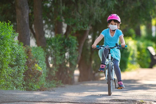 Menina Máscara Médica Protetora Monta Uma Bicicleta — Fotografia de Stock