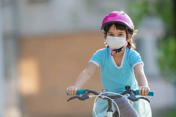 Menina Máscara Médica Protetora Monta Uma Bicicleta — Fotografia de Stock