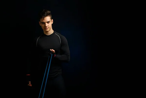 Joven Atleta Uniforme Negro Para Estira Una Banda Elástica Deportiva —  Fotos de Stock