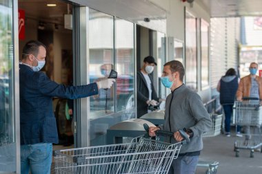 Galati Romanya - 6 Mayıs 2020: Süpermarkette sıcaklık kontrolü, termal kameralı bakkal. Resim izleme tarayıcısı müşterinin vücut ısısı.