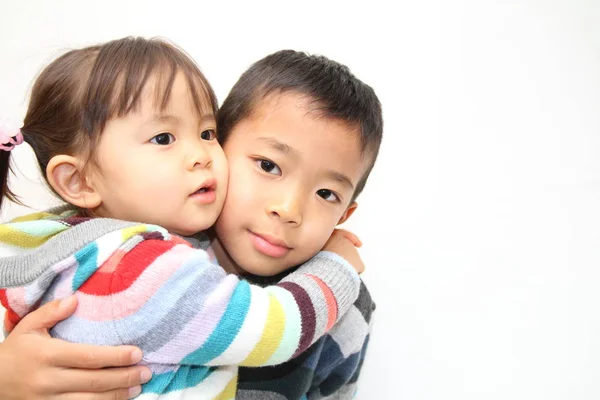 Japanska bror och syster kramar varandra (7 år gammal pojke och 2 år gammal flicka) — Stockfoto