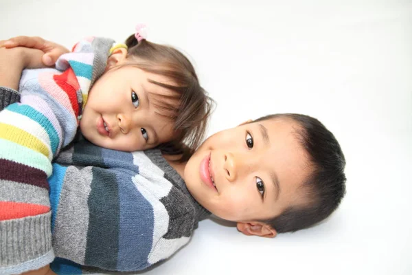 Japanisch Bruder und Schwester umarmen einander (7 Jahre alter Junge und 2 Jahre altes Mädchen)) — Stockfoto