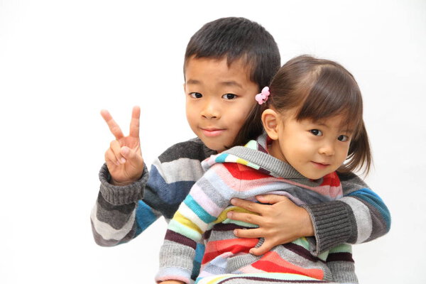 Japanese brother and sister sitting on his knee (7 years old boy and 2 years old girl)