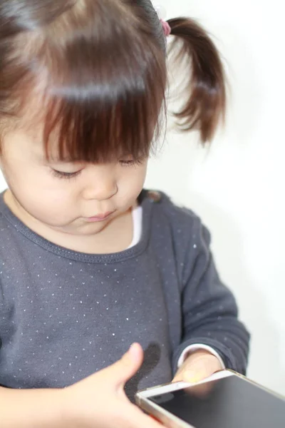 Japán lány segítségével egy okos telefon (2 éves korig) — Stock Fotó