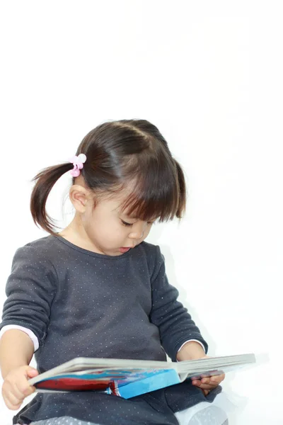 Niña japonesa leyendo un libro ilustrado (2 años) ) — Foto de Stock