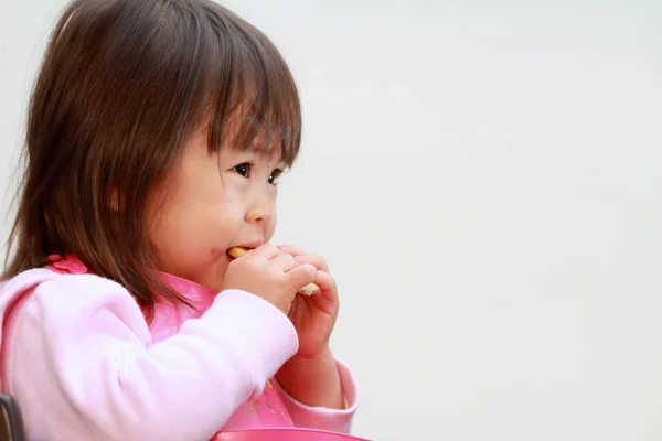 Japans meisje eten rijst kraker (2 jaar oud) — Stockfoto