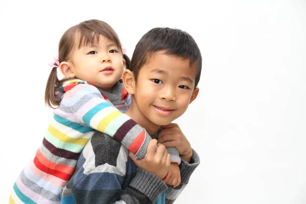 Японський хлопець, проведення своєї сестри на спині (7 років хлопчик і 2 років old дівчина) — стокове фото