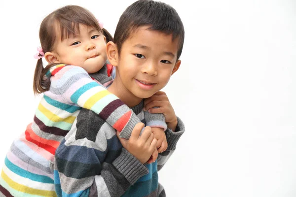 日本男児の背中 (7 歳の男の子と 2 年古い女の子に彼の妹を運ぶ) — ストック写真